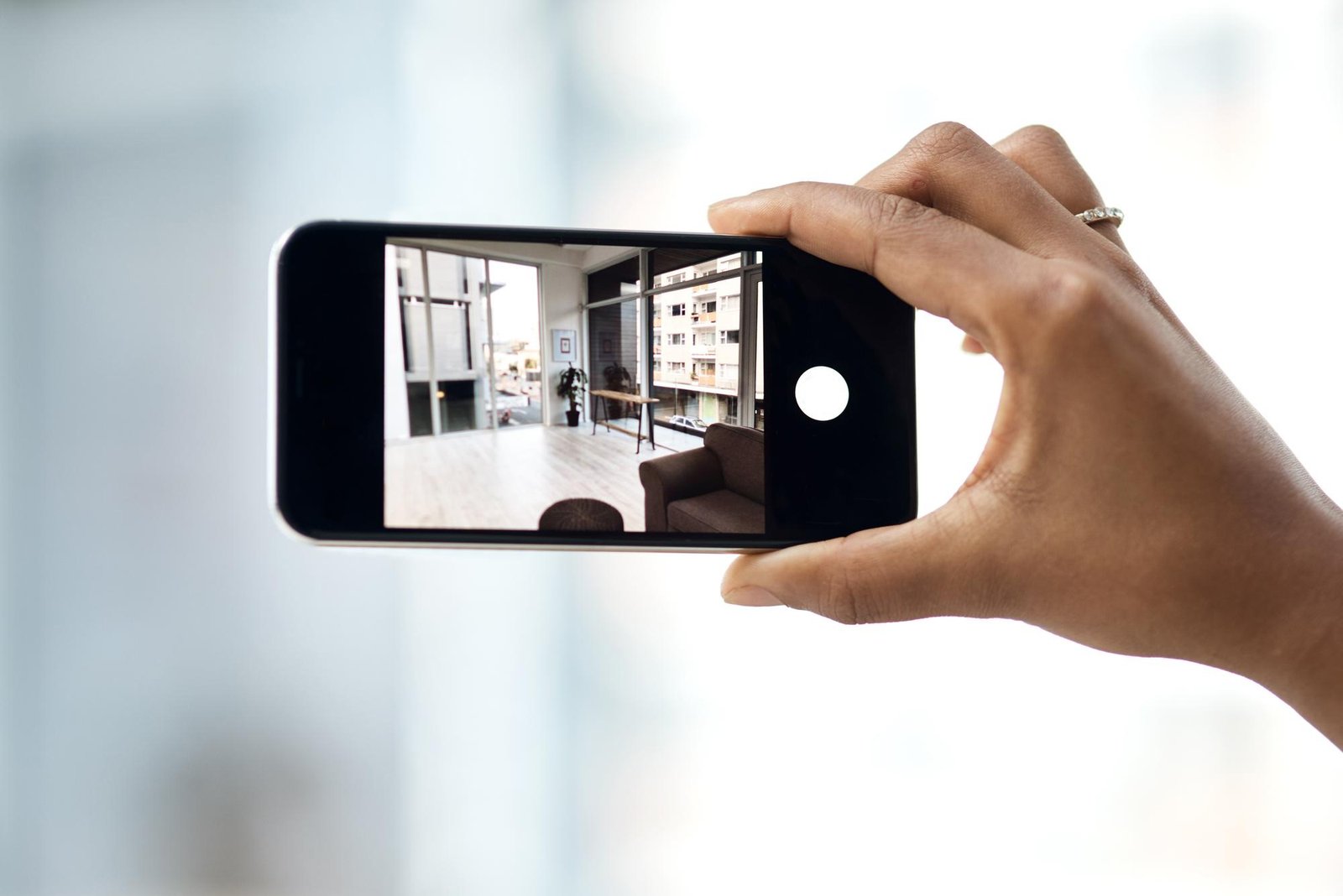 home-viewings-gone-virtual-cropped-shot-unrecognisable-woman-photographing-interior-house-with-smartphone