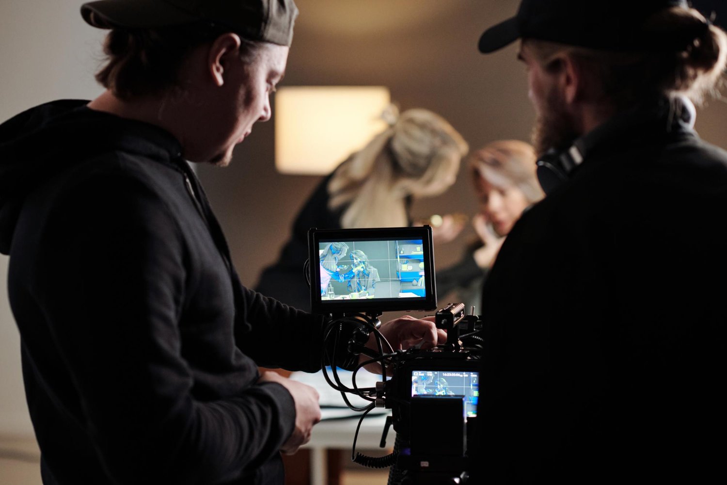 two-young-men-black-shirts-adjusting-focus-camera-during-shooting